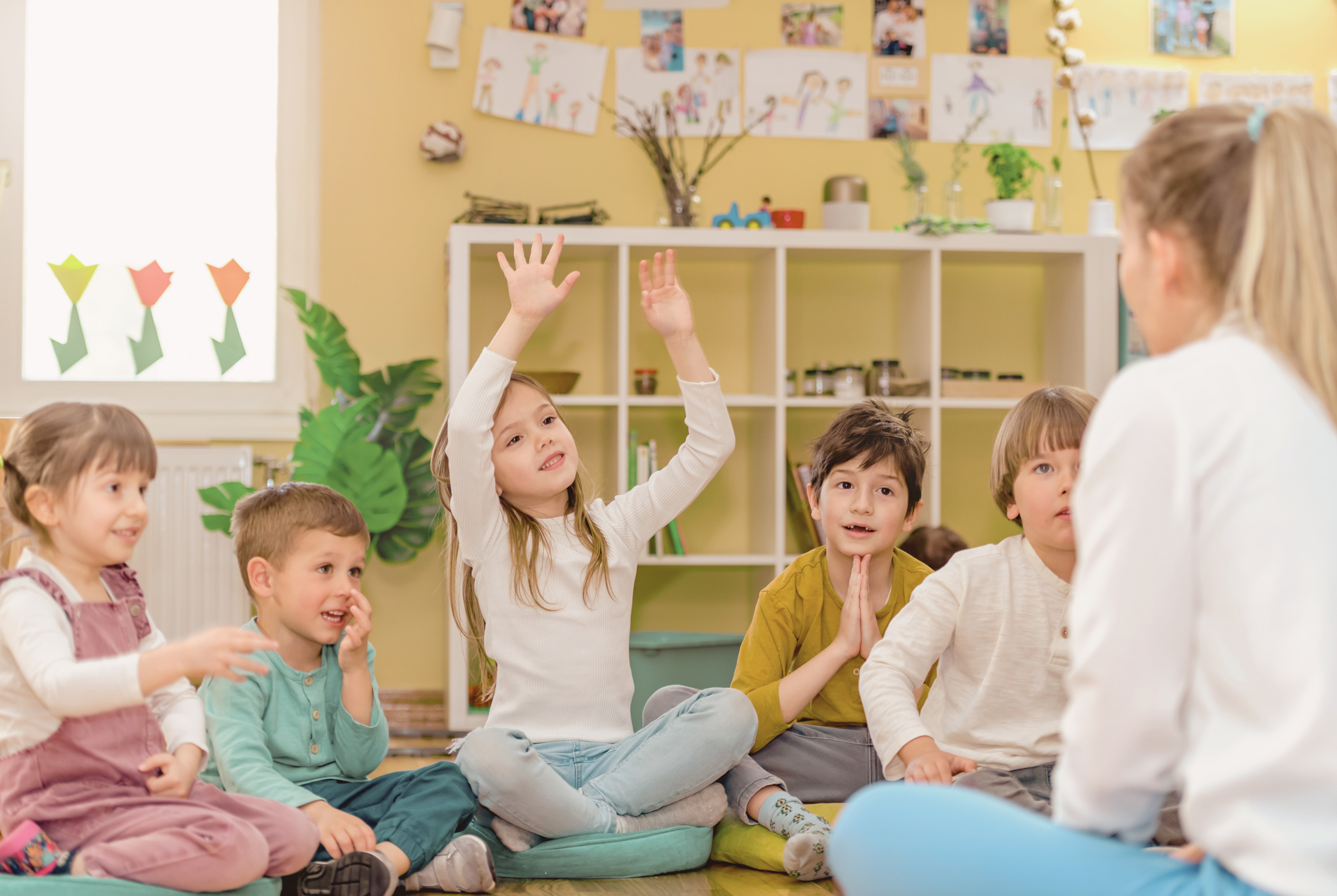 孩子專心聆聽老師說話並舉手互動，練習聽覺專注力與聽覺記憶
